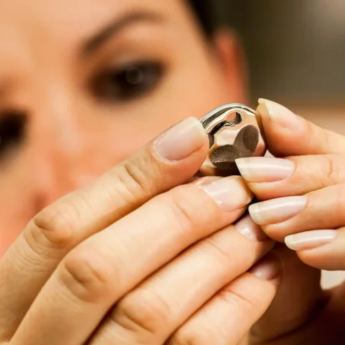 Polieren einer silbernen Hundemarke mit Filzscheibe