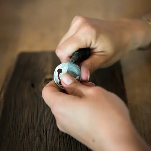 Maira beim Punzieren einer fertigen Hundemarke