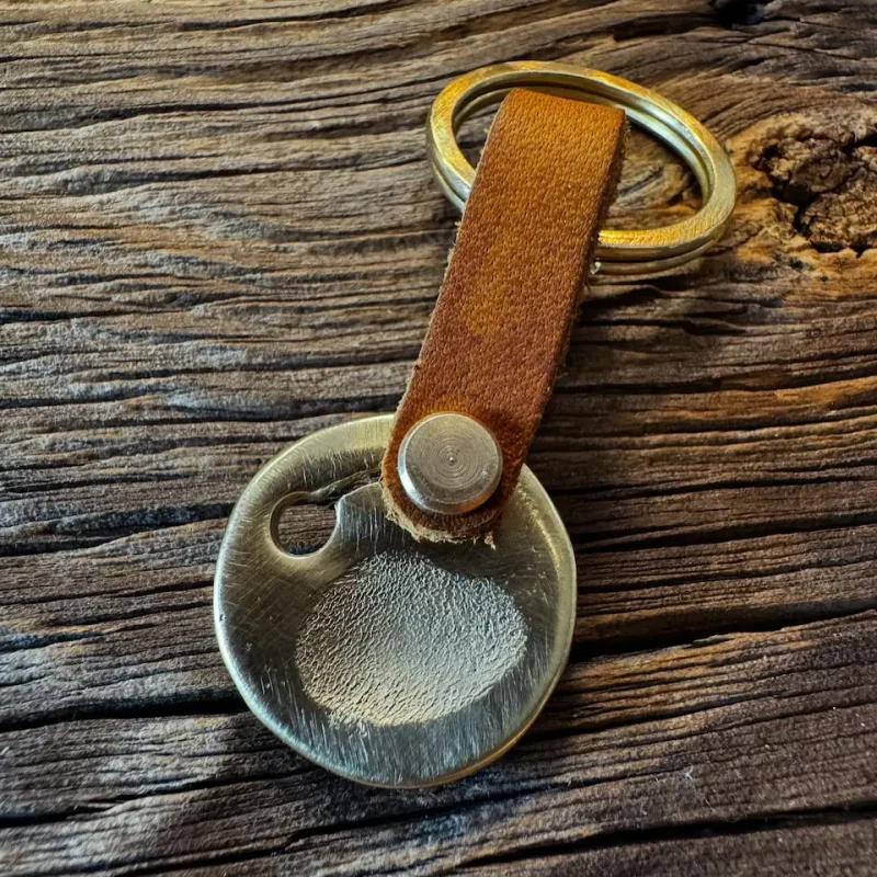 Goldene Hundemarke mit Pfotenabdruck und Gravur